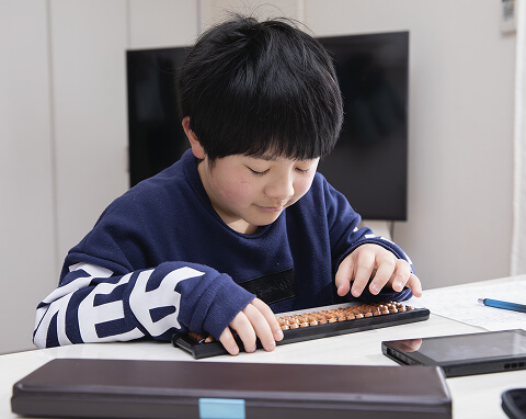 そろばんをする子どもの写真