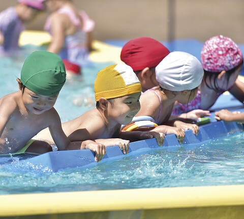 プールで泳ぐ子どもの写真